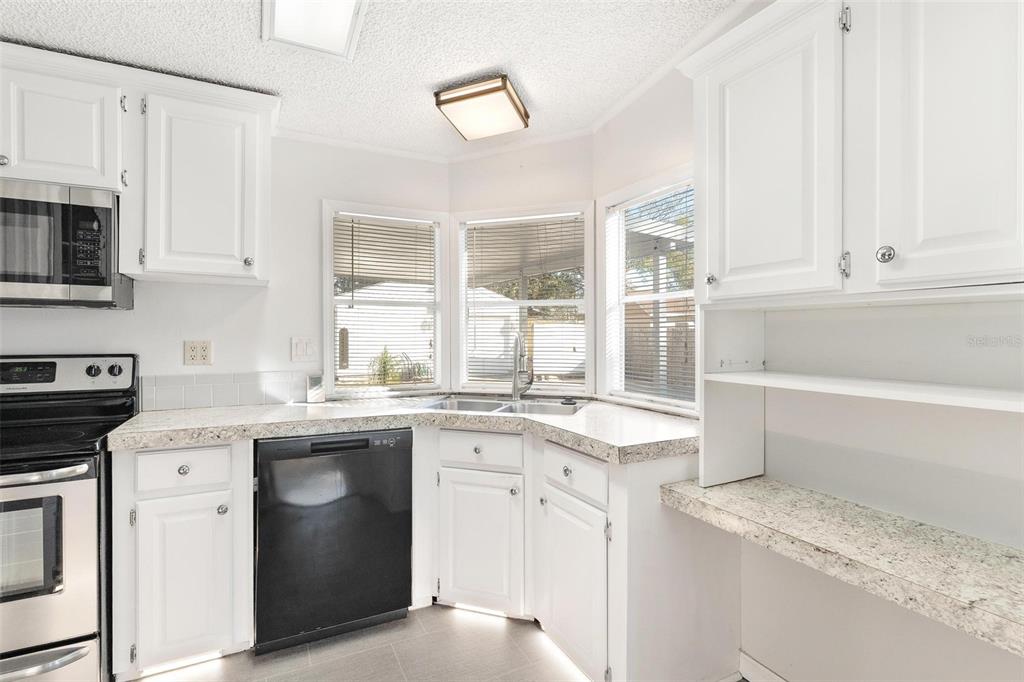 36832 Wilmington Road Fruitland Park, FL 34731 - Photo 9 of 14 a kitchen with stainless steel appliances granite countertop a sink stove and cabinets