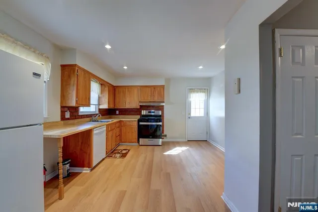 a kitchen with sink a refrigerator and chairs