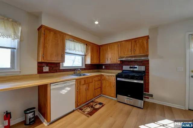 a kitchen with a sink appliances cabinets and a window