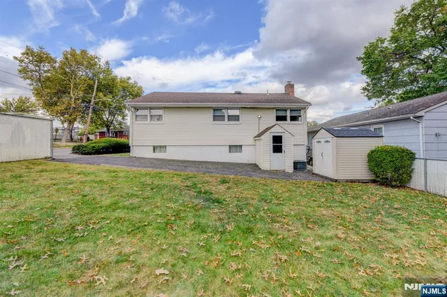 a large white house with a large tree and a yard in front of it