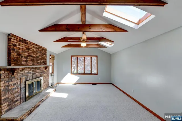 an empty room with windows and fireplace