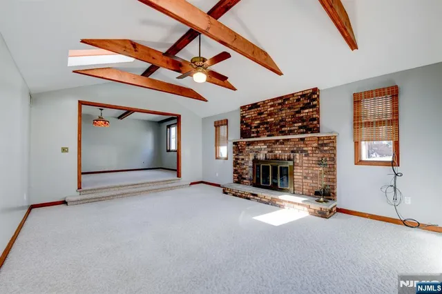 a view of an empty room with window and fireplace