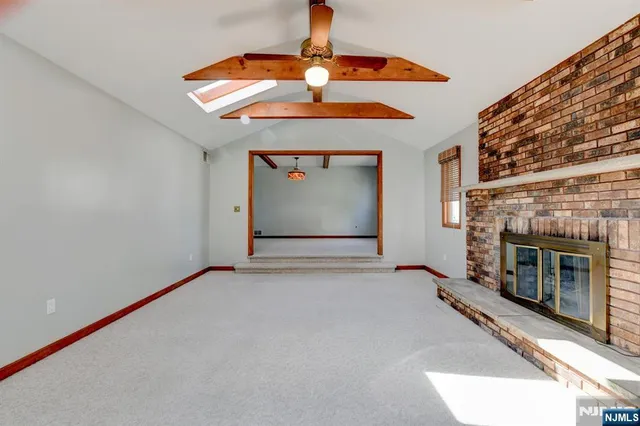 an empty room with a fireplace and chandelier fan