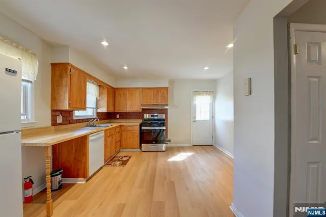 a kitchen with a refrigerator a sink and a stove top oven