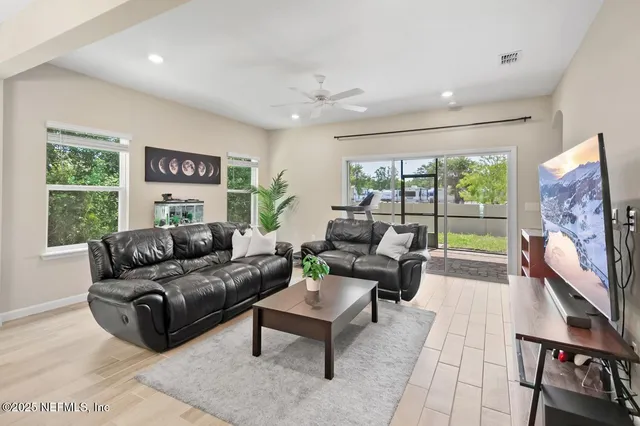 a living room with furniture a large window and a flat screen tv