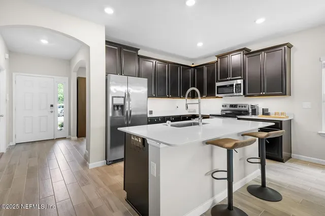 a kitchen with stainless steel appliances granite countertop a refrigerator a stove a sink and a oven