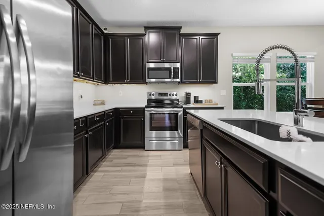 a kitchen with stainless steel appliances granite countertop a sink stove and refrigerator