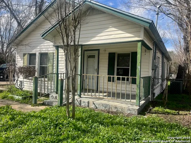 a view of a brick house with large windows and a yard