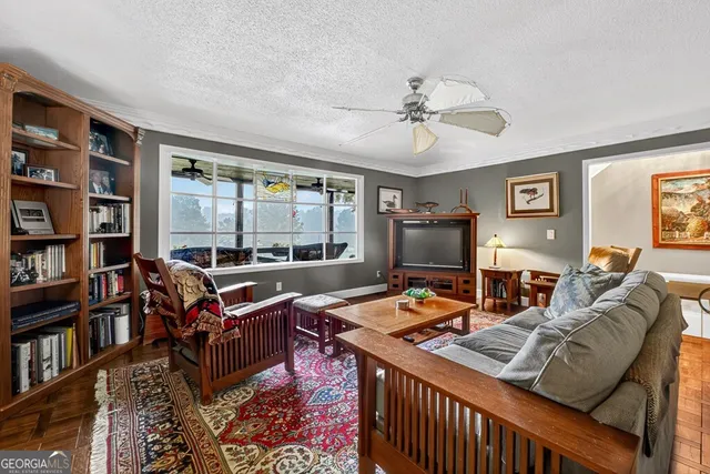 a living room with furniture a bookshelf and a window