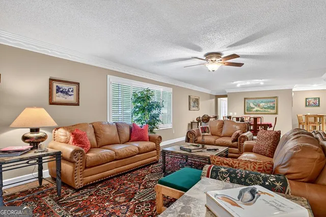 a bedroom with a large bed a chandelier and dresser