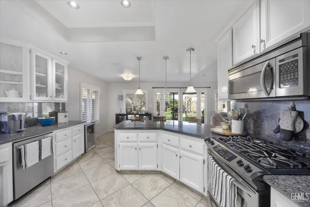 a kitchen with stainless steel appliances granite countertop a stove and cabinets