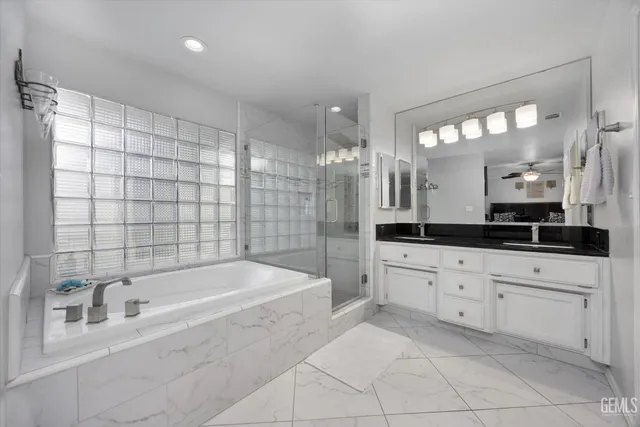 a bathroom with a granite countertop sink a toilet a mirror and shower