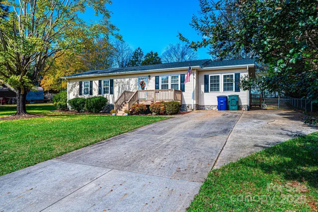 a front view of a house with a yard and trees