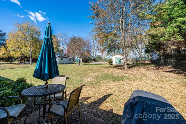 a view of a backyard with table and chairs with wooden fence