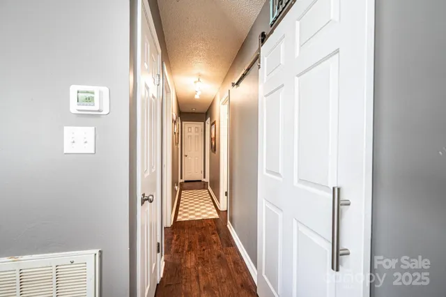 a view of a hallway with wooden floor and staircase