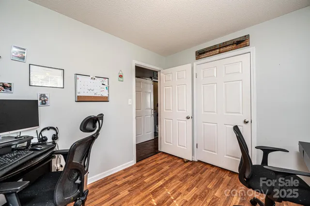 a view of a workspace with furniture and wooden floor