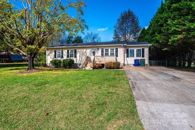 a front view of a house with a yard and trees