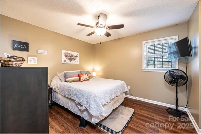 a bedroom with bed and wooden floor