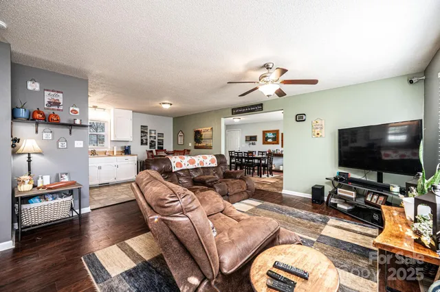 a living room with furniture a flat screen tv and a large window