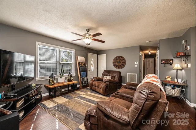 a dining room with stainless steel appliances kitchen island granite countertop a dining table chairs and a refrigerator