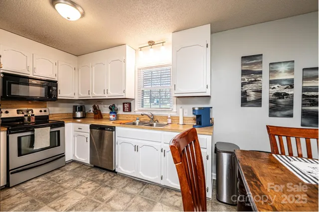 a kitchen with stainless steel appliances granite countertop a sink and a white cabinets