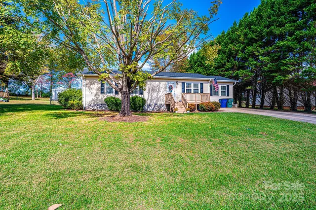a view of a house with a big yard and large trees