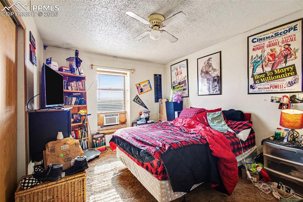 921 Candlestar Loop North Fountain, CO 80817 - Photo 15 of 23 a bedroom with a bed dresser and flat screen tv