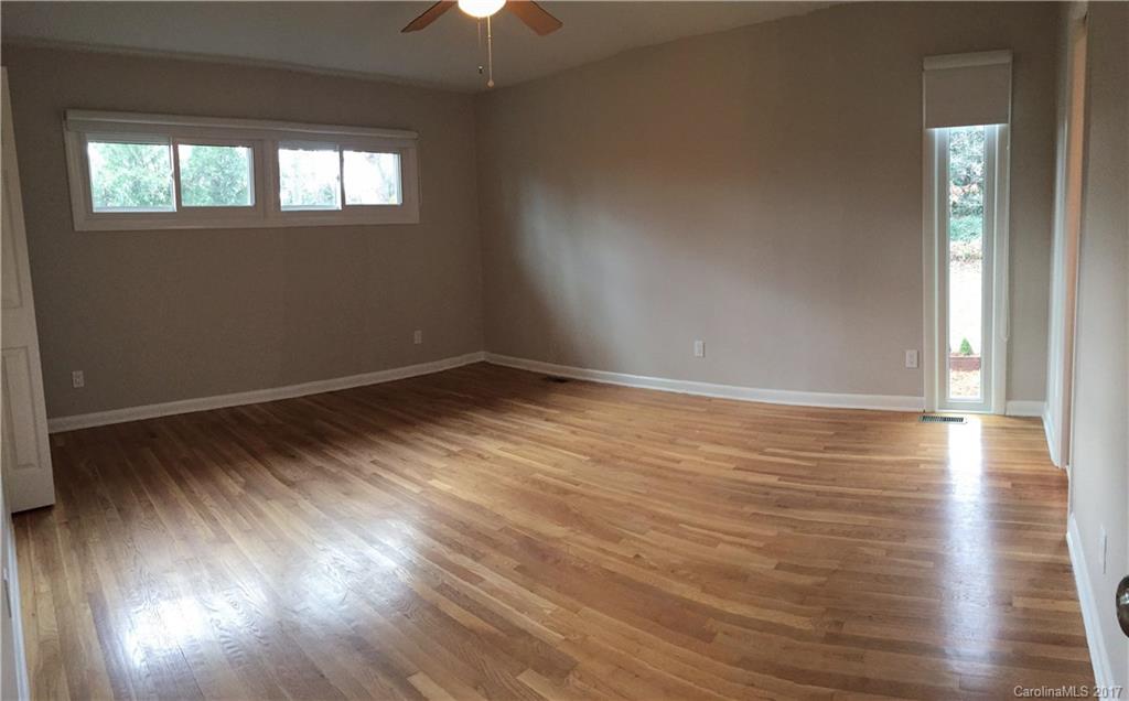 330 Whitestone Road Charlotte, NC 28270 - Photo 9 of 23 an empty room with wooden floor chandelier fan and windows