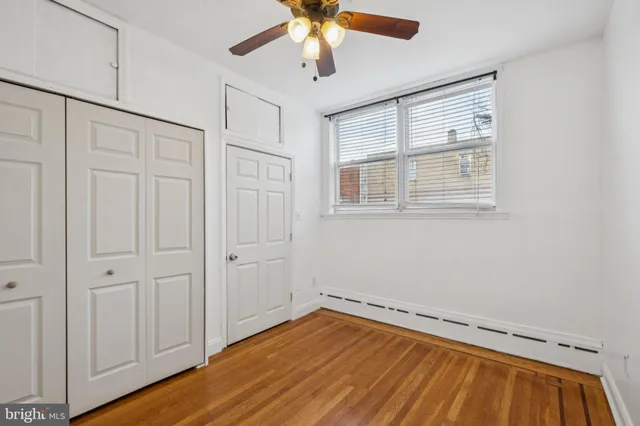 a view of a livingroom with wooden floor and a ceiling fan