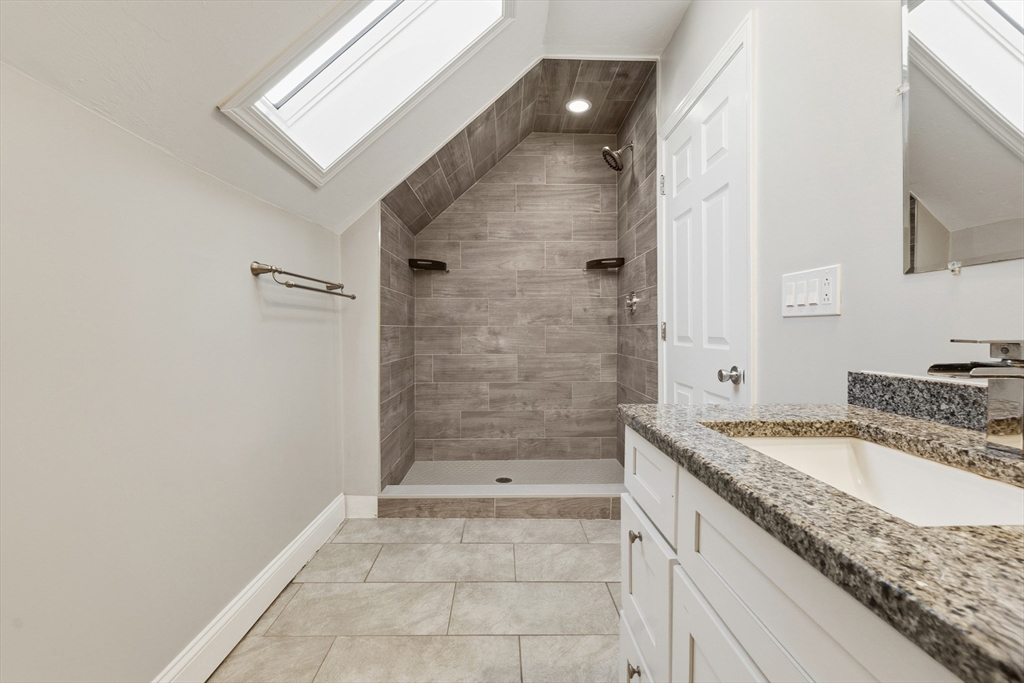 21 Emerton Street, Unit 2 Salem, MA 01970 - Photo 26 of 33 a bathroom with a granite countertop sink a mirror and shower