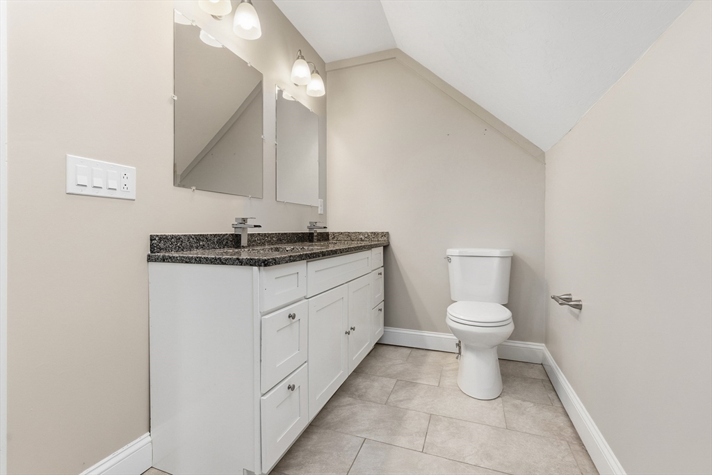21 Emerton Street, Unit 2 Salem, MA 01970 - Photo 27 of 33 a bathroom with a granite countertop toilet sink and mirror