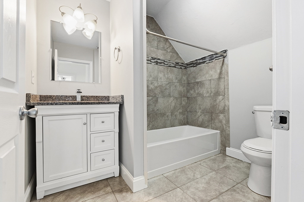 21 Emerton Street, Unit 2 Salem, MA 01970 - Photo 32 of 33 a bathroom with a granite countertop sink a toilet and a mirror