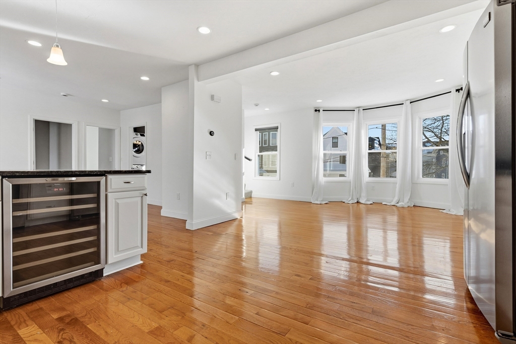 21 Emerton Street, Unit 2 Salem, MA 01970 - Photo 6 of 33 a view of an empty room with wooden floor and a kitchen
