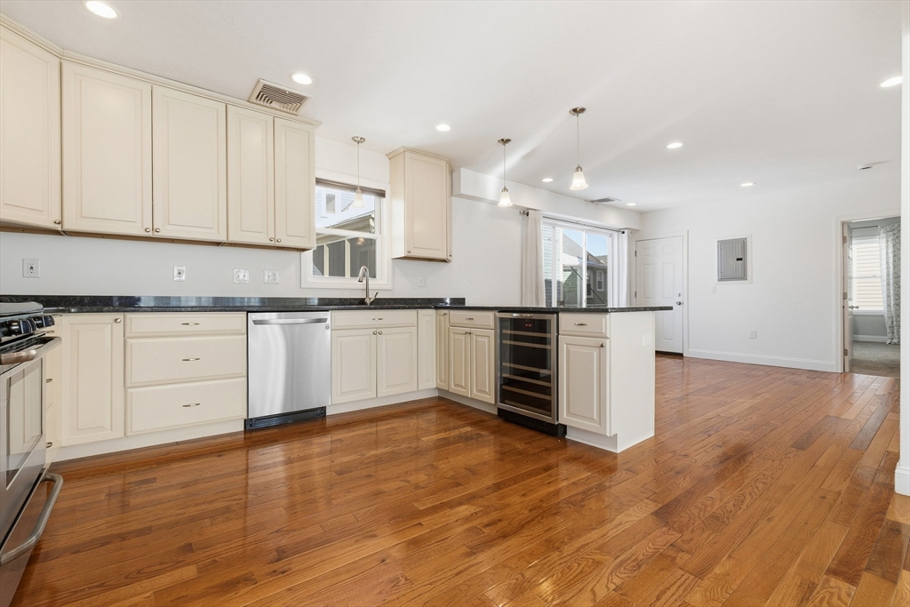 21 Emerton Street, Unit 2 Salem, MA 01970 - Photo 7 of 33 a kitchen with stainless steel appliances granite countertop a stove top oven a sink and white cabinets with wooden floor
