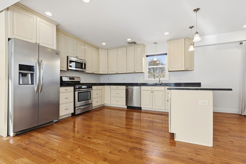 21 Emerton Street, Unit 2 Salem, MA 01970 - Photo 8 of 33 a kitchen with stainless steel appliances granite countertop a refrigerator a stove a sink and a microwave