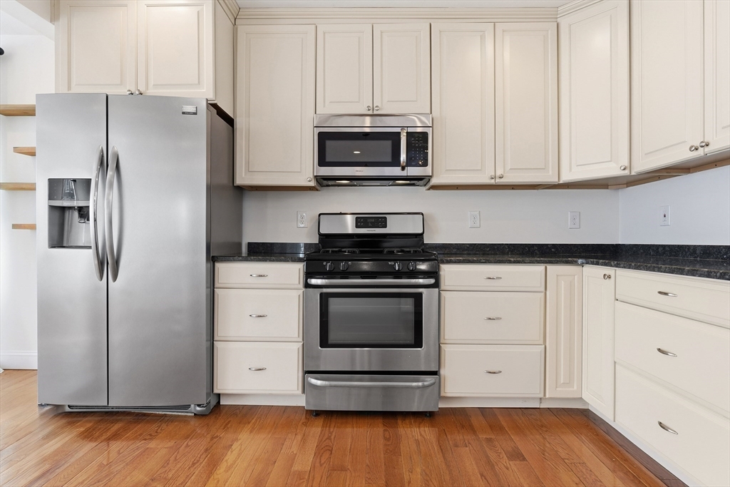 21 Emerton Street, Unit 2 Salem, MA 01970 - Photo 9 of 33 a kitchen with stainless steel appliances white cabinets and a refrigerator