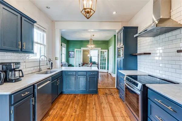 a kitchen with stainless steel appliances granite countertop a sink a stove top oven a counter space and cabinets