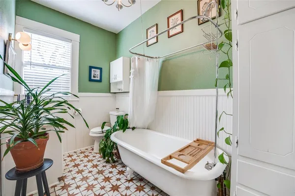 a white bath tub sitting in a bathroom next to a window