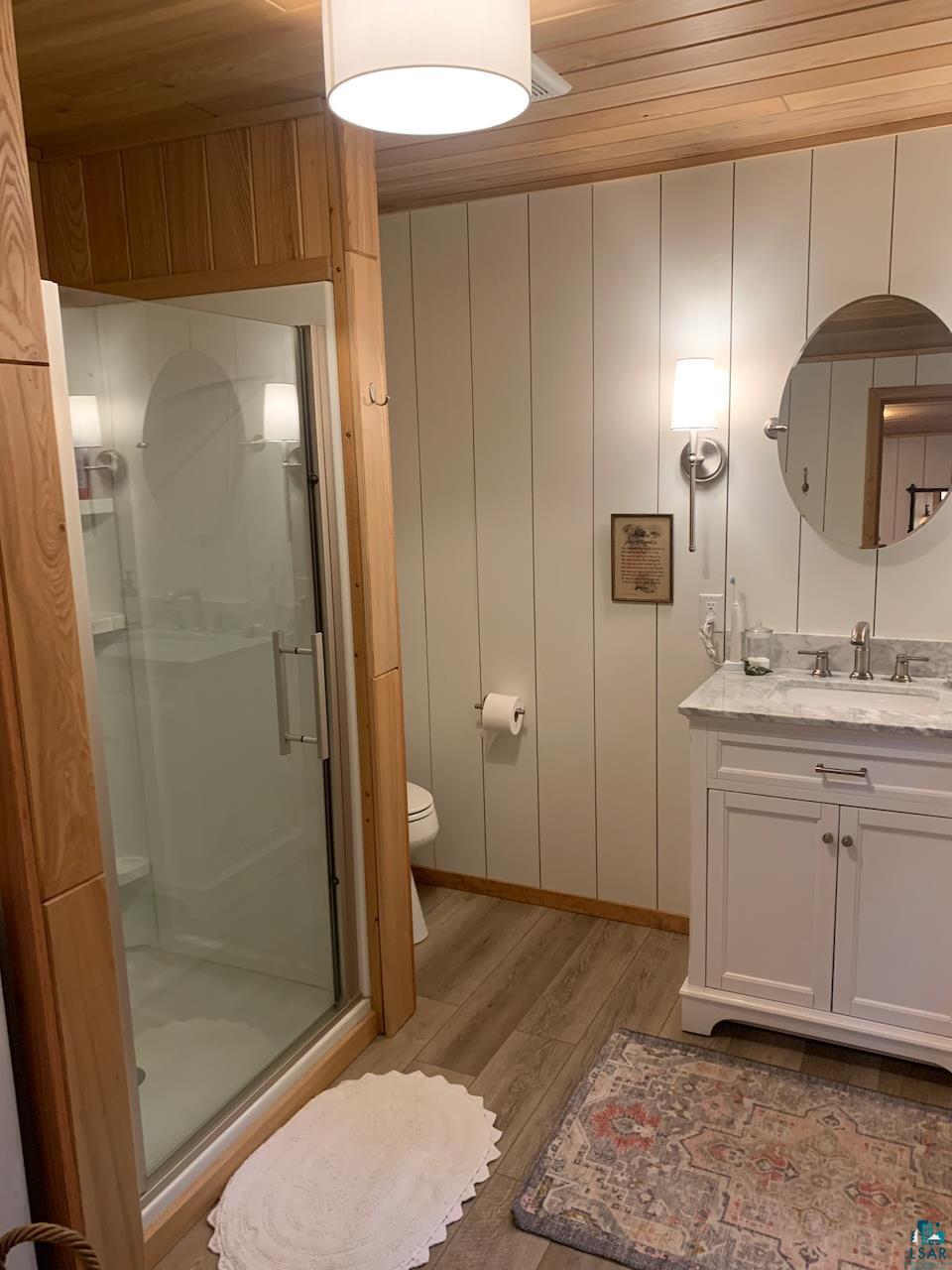 2903 Chaps Road Cook, MN 55723 - Photo 20 of 30 Full bathroom featuring vanity, a stall shower, light wood finished floors, and wooden ceiling