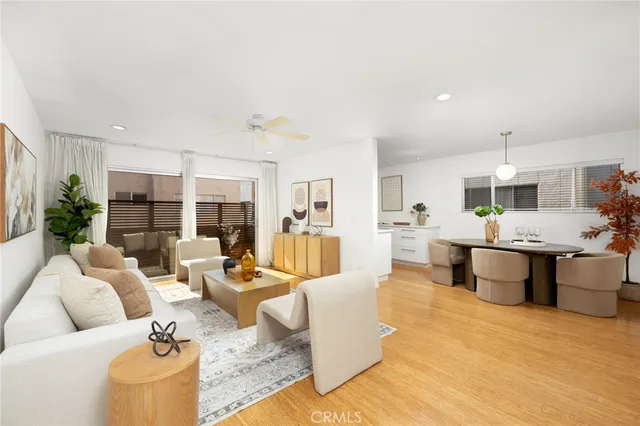a living room with furniture kitchen view and large windows