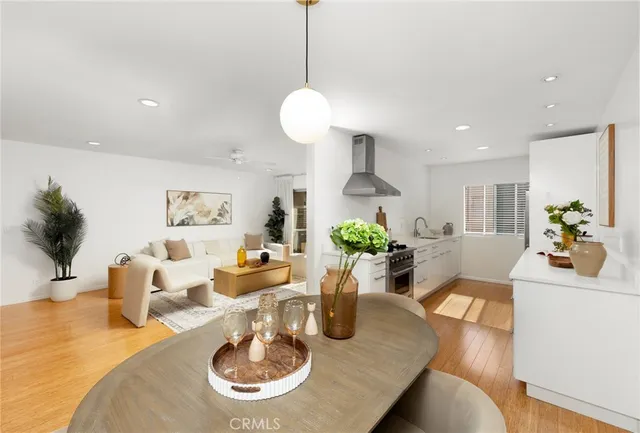 a dining room with wooden floor a chandelier a wooden table and chairs