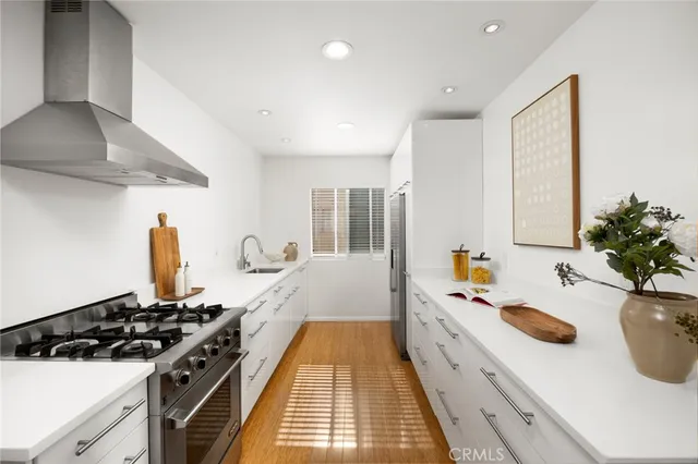a kitchen with a sink a stove and a wooden floors