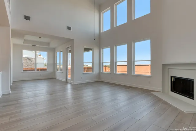 a kitchen with stainless steel appliances granite countertop a stove a sink dishwasher a refrigerator and a fireplace with wooden floor