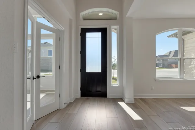 a view of a hallway with wooden floor and entryway