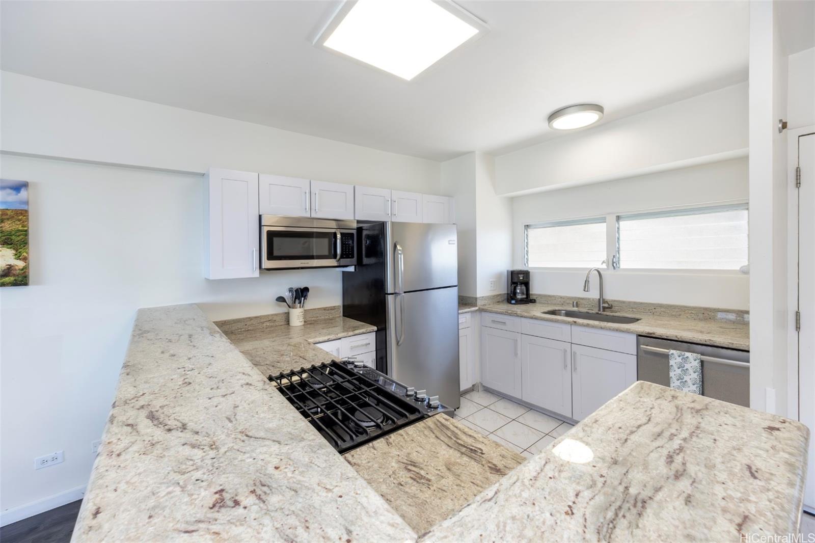 2161 Kalia Road, Unit 1012 Honolulu, HI 96815 - Photo 16 of 25 a kitchen with granite countertop a stove sink and refrigerator