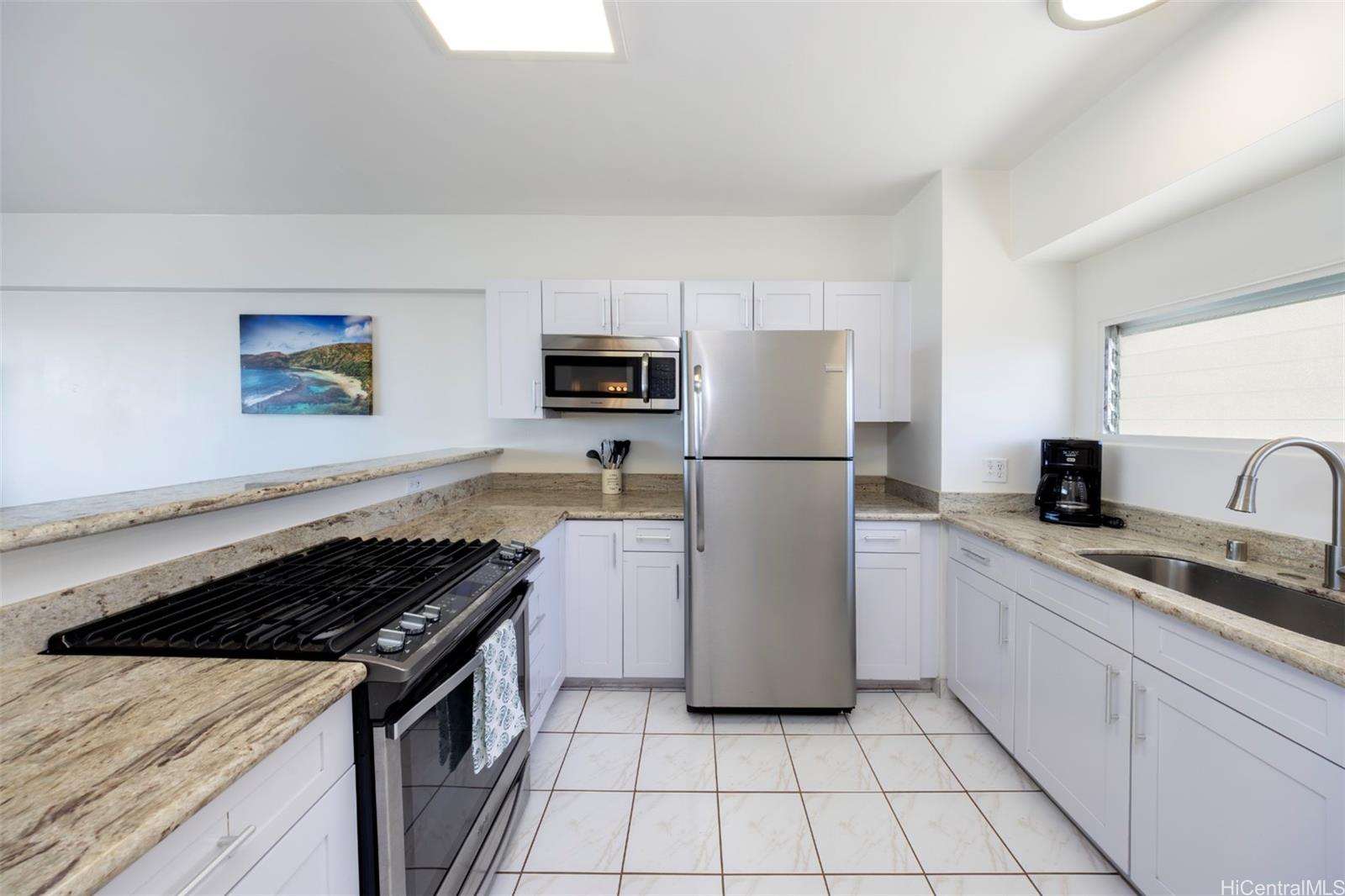 2161 Kalia Road, Unit 1012 Honolulu, HI 96815 - Photo 17 of 25 a kitchen with a refrigerator sink and white cabinets