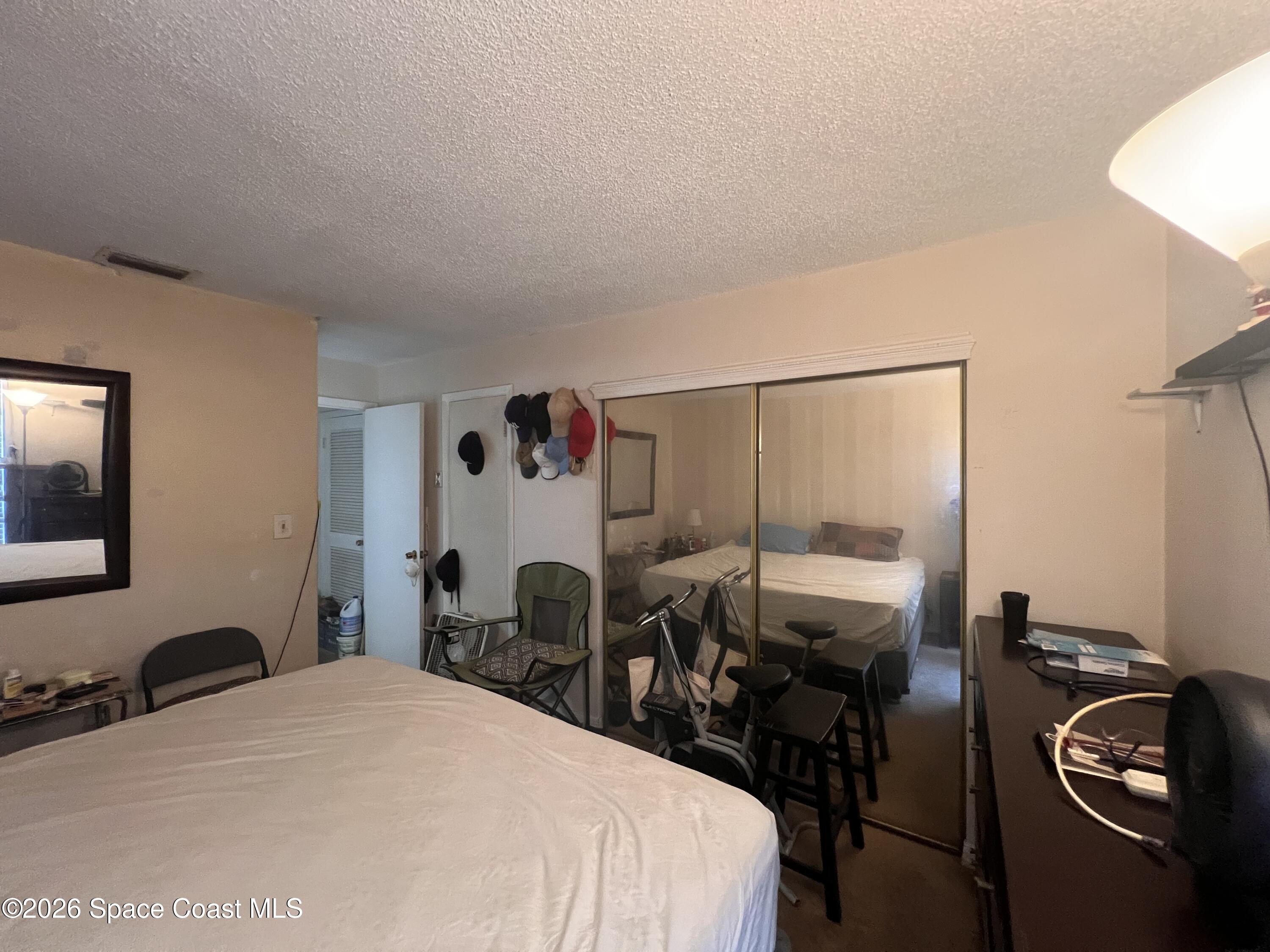 1225 North Wickham Road, Unit 623 Melbourne, FL 32935 - Photo 15 of 20 a bed room with a bed and dresser
