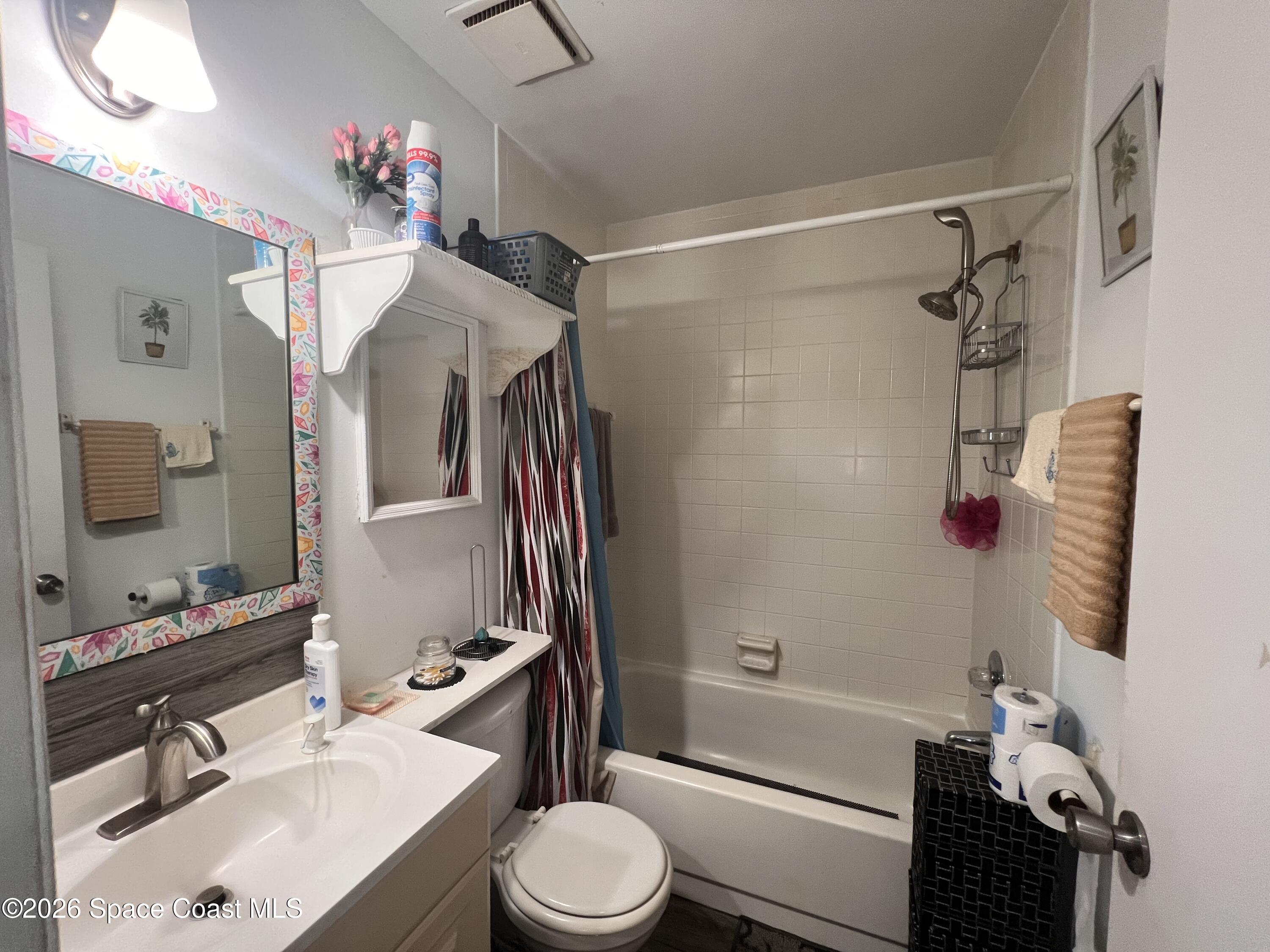 1225 North Wickham Road, Unit 623 Melbourne, FL 32935 - Photo 17 of 20 a bathroom with a sink vanity mirror bathtub shower and toilet