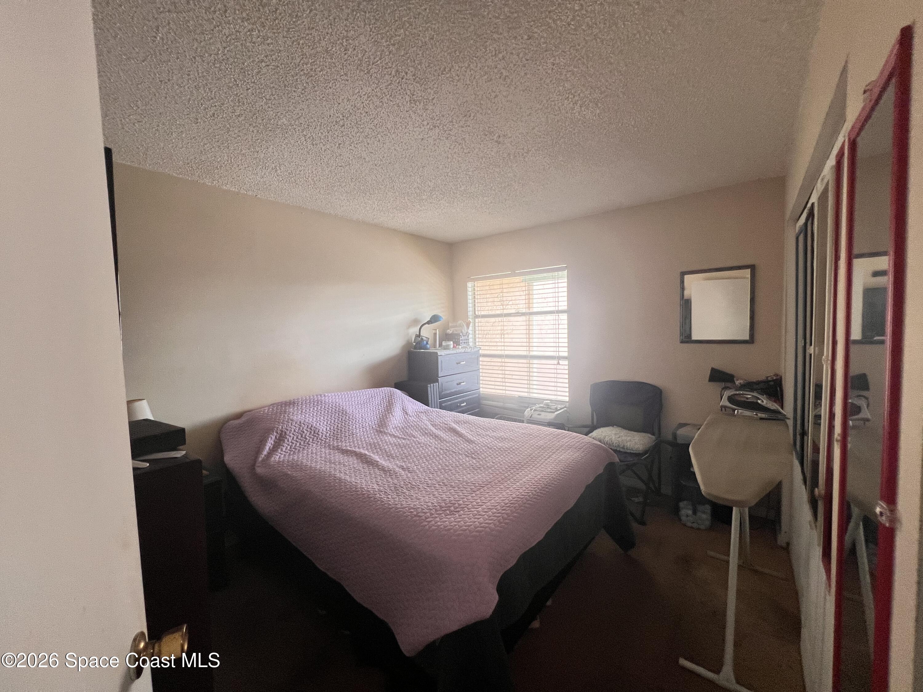 1225 North Wickham Road, Unit 623 Melbourne, FL 32935 - Photo 19 of 20 a bedroom with a bed and a window