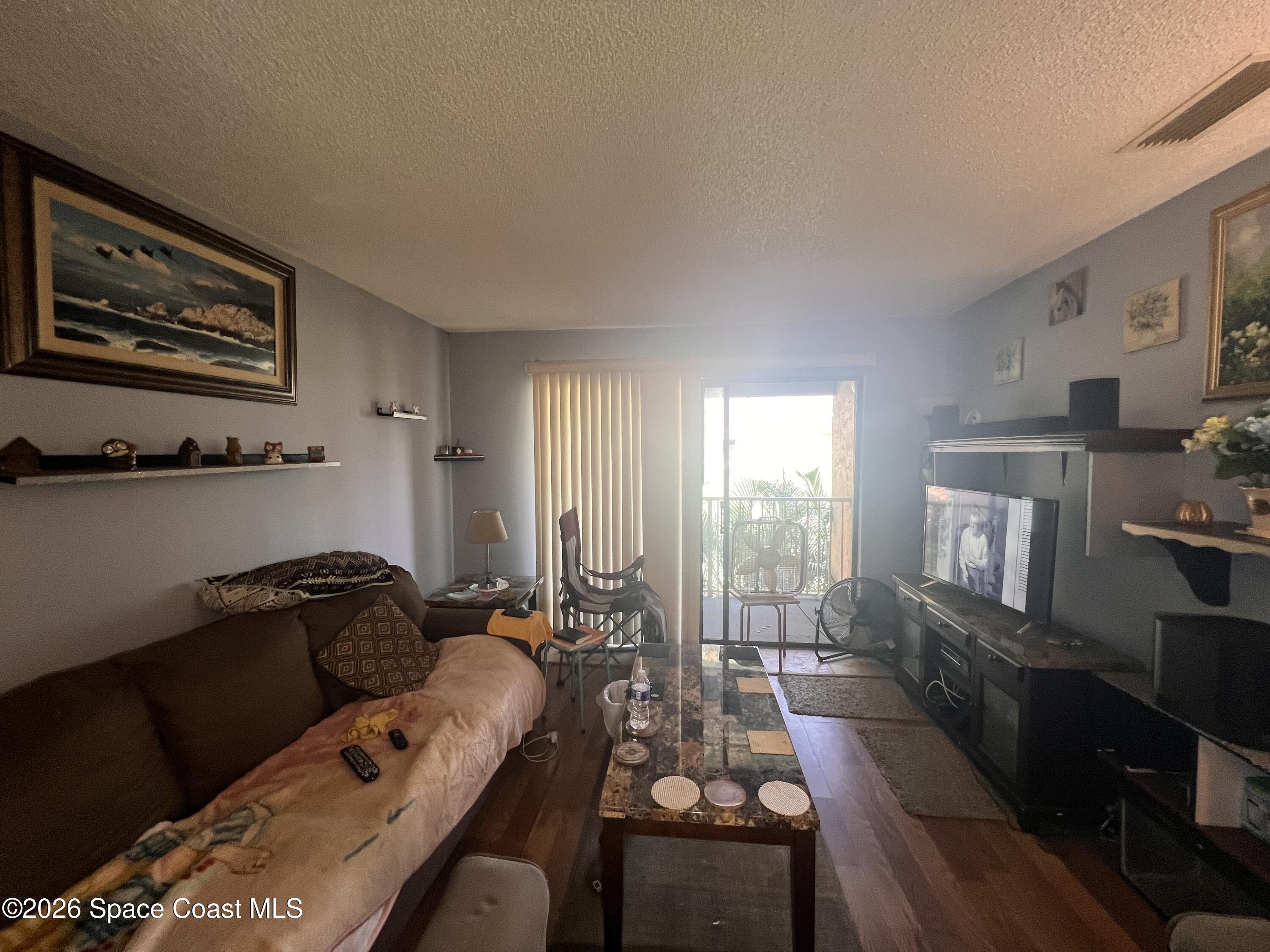 1225 North Wickham Road, Unit 623 Melbourne, FL 32935 - Photo 7 of 20 a living room with furniture window and wooden floor